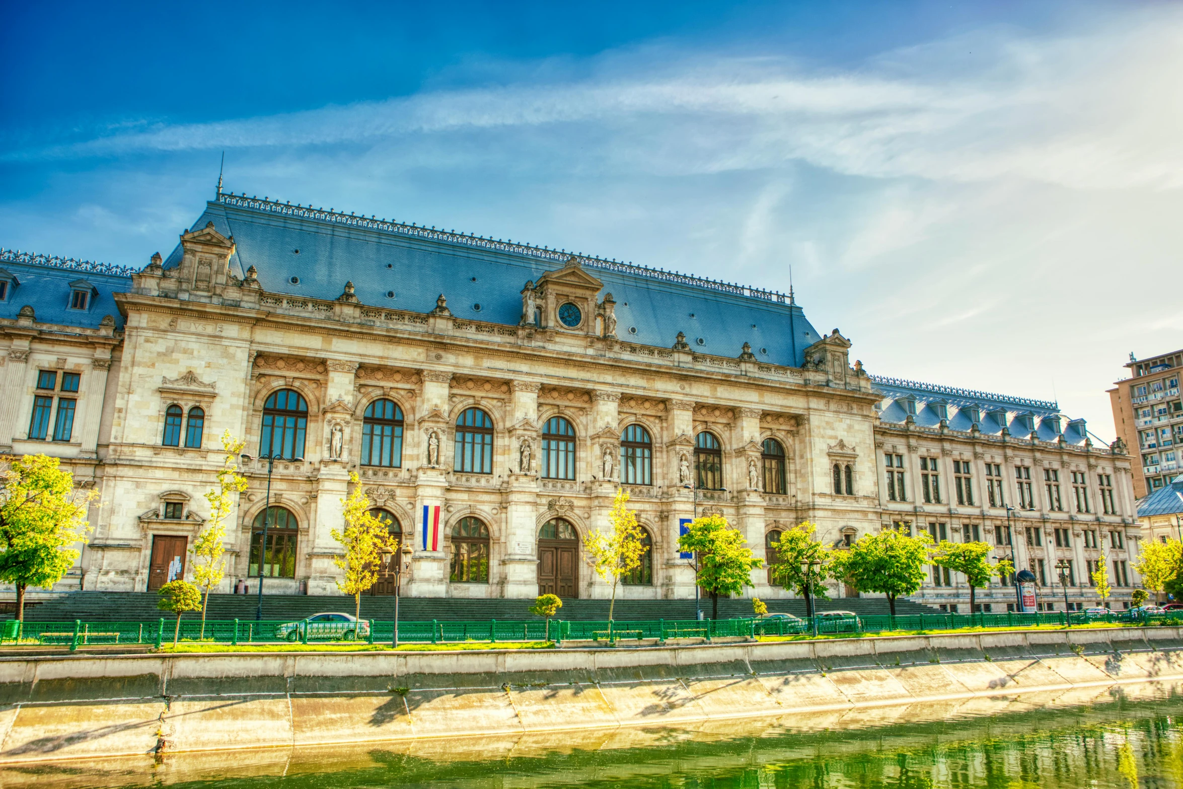 a large building next to a body of water, a photo, inspired by Jules Robert Auguste, pexels contest winner, renaissance, prefecture streets, promo image, romanian heritage, thumbnail