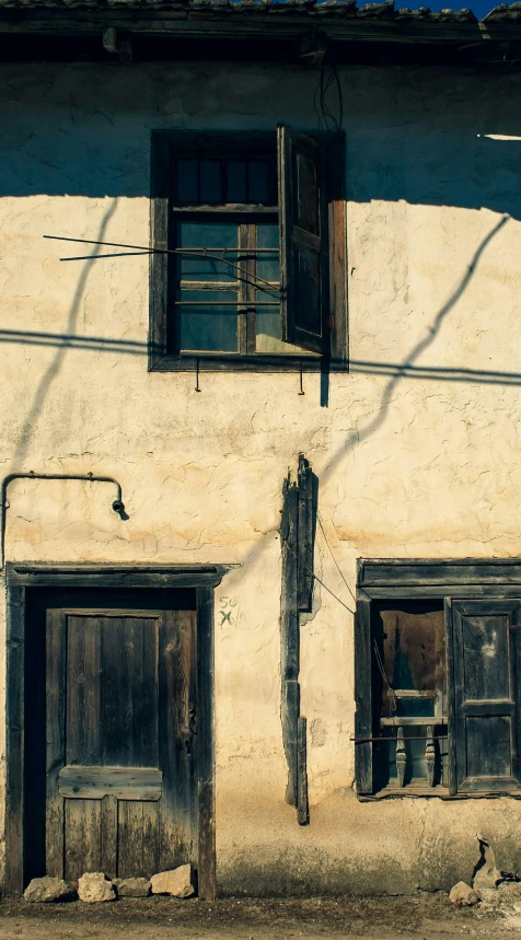 a building with a bunch of cats in front of it, unsplash, mingei, sanjulian. detailed texture, wires hanging across windows, a wooden, sunlit