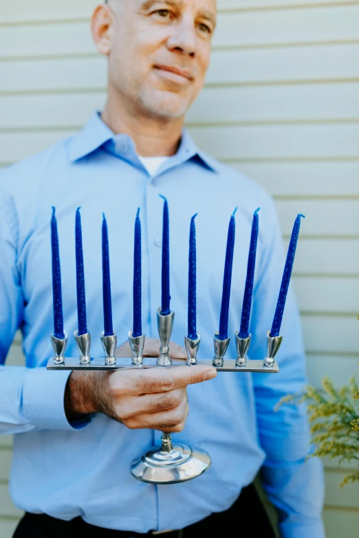 a man holding a menorah with blue candles, kobalt blue, with a sleek spoiler, holiday, featuring rhodium wires