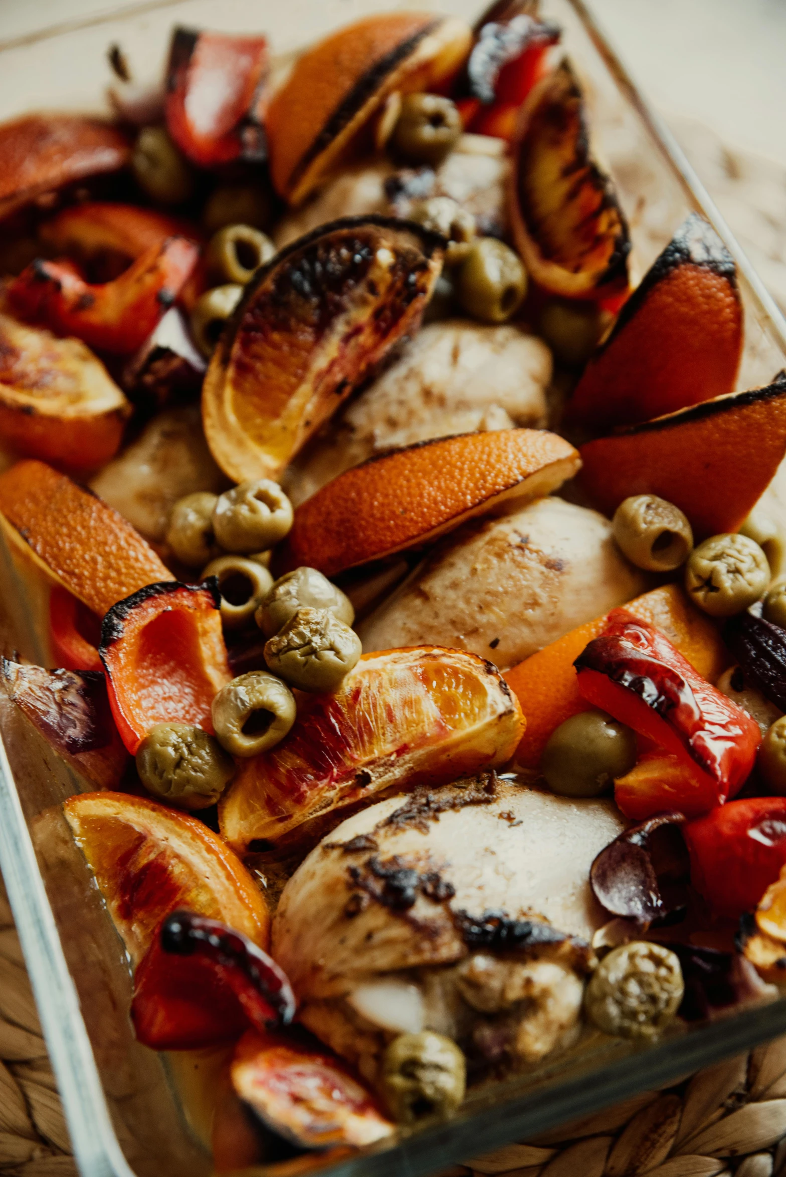 a close up of a tray of food on a table, inspired by Géza Dósa, grilled chicken, dead fruits, orange details, weathered olive skin