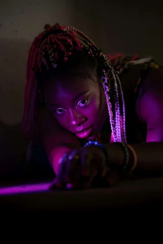 a woman laying on top of a bed next to a laptop computer, by artist, trending on pexels, afrofuturism, posing in dramatic lighting, glowing purple led eyes, film movie still, glowing with colored light