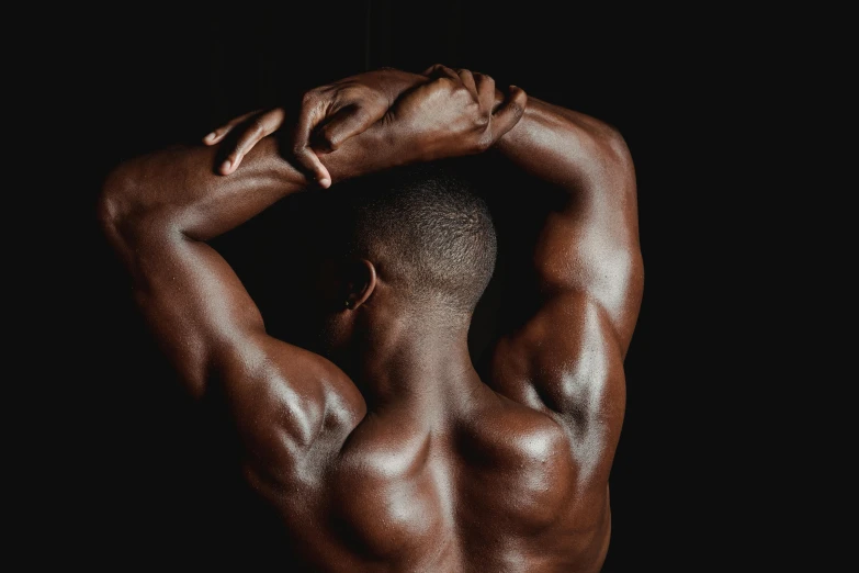 a man standing in front of a black background, bare back, ebony skin, steroid use, armpit