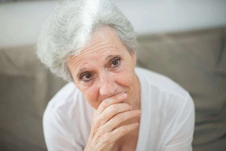 a close up of a person sitting on a couch, white haired lady, concern, close up photograph, portrait image