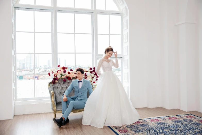 a man sitting on a chair next to a woman in a wedding dress, by Natasha Tan, unsplash, doing an elegant pose over you, official store photo, sakimichan hdri, white room