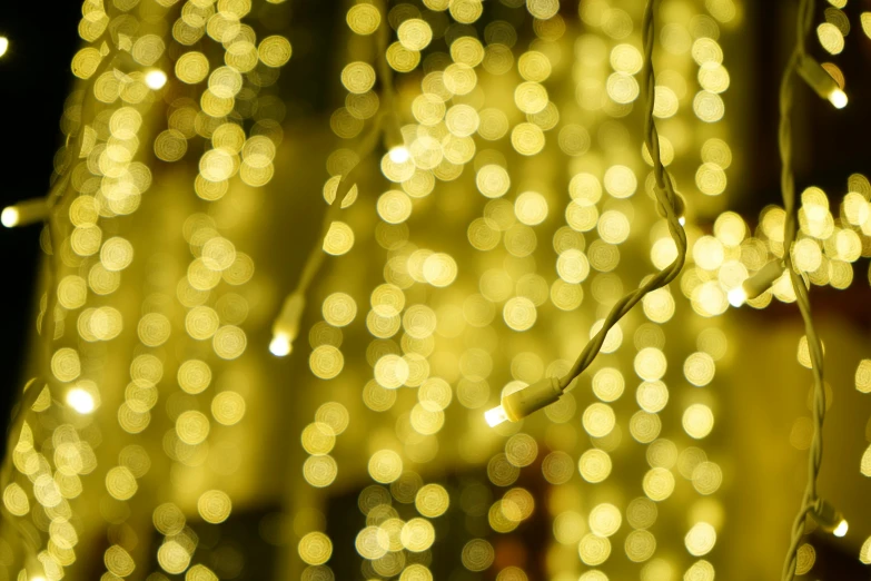 a close up of a string of lights, gold waterfalls, gold dappled light, cheesy, full res