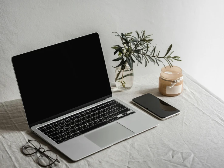 a laptop computer sitting on top of a table next to a cell phone, trending on pexels, white backround, silver accessories, brown, black + white