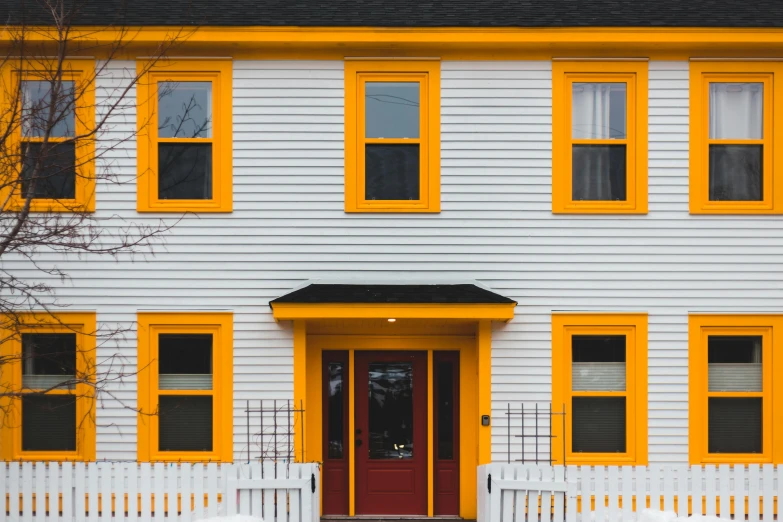 a yellow and white house with a red door, pexels contest winner, hyperrealism, black windows, orange yellow, new england architecture, multicolored