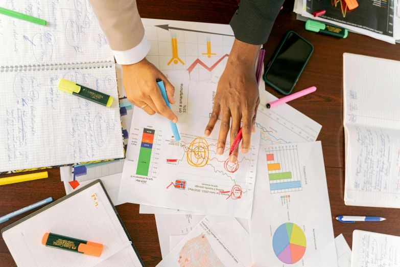 a person sitting at a table with papers and pens, analytical art, informative graphs and diagrams, a brightly colored, thumbnail, inspect in inventory image