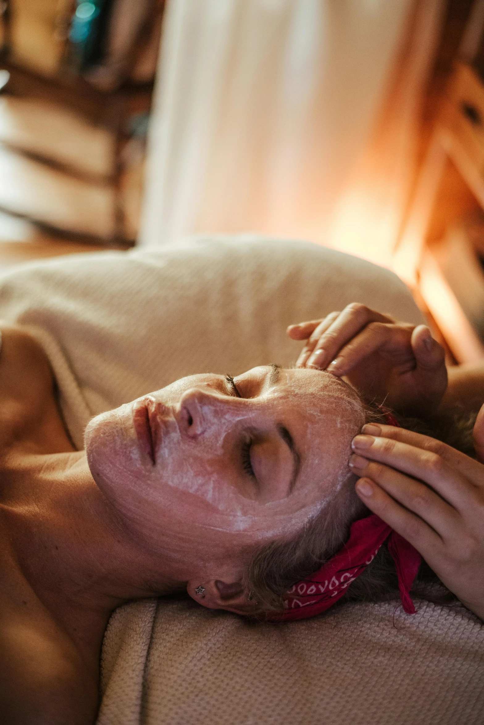 a man laying on a couch getting a facial mask, a portrait, by Julia Pishtar, trending on pexels, renaissance, sunset glow around head, blonde, paradise garden massage, manuka