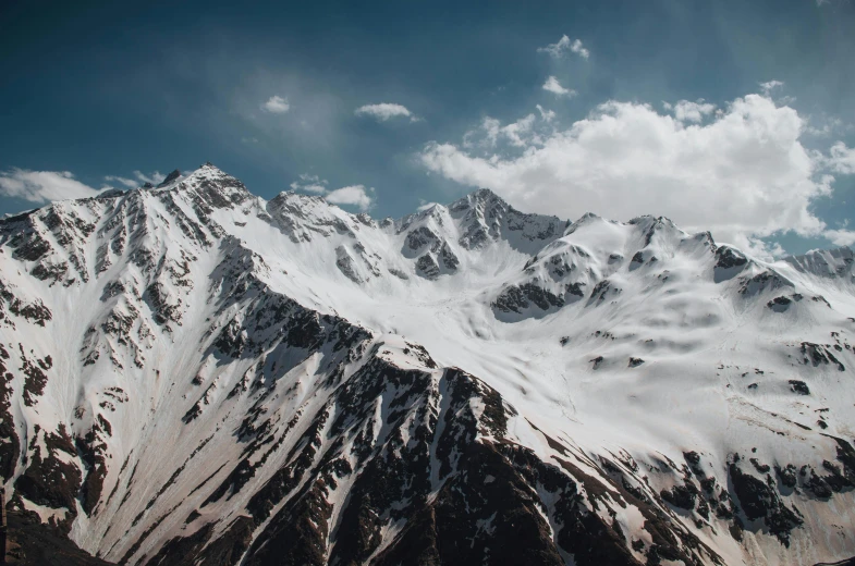 a large mountain covered in snow under a blue sky, pexels contest winner, craggy mountains, unsplash 4k, multiple stories, grey