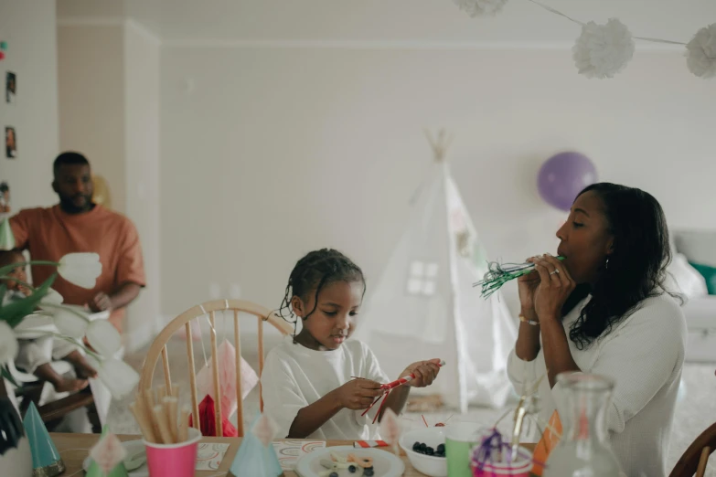 a woman and a little girl sitting at a table, pexels contest winner, at a birthday party, avatar image, children painting, diverse