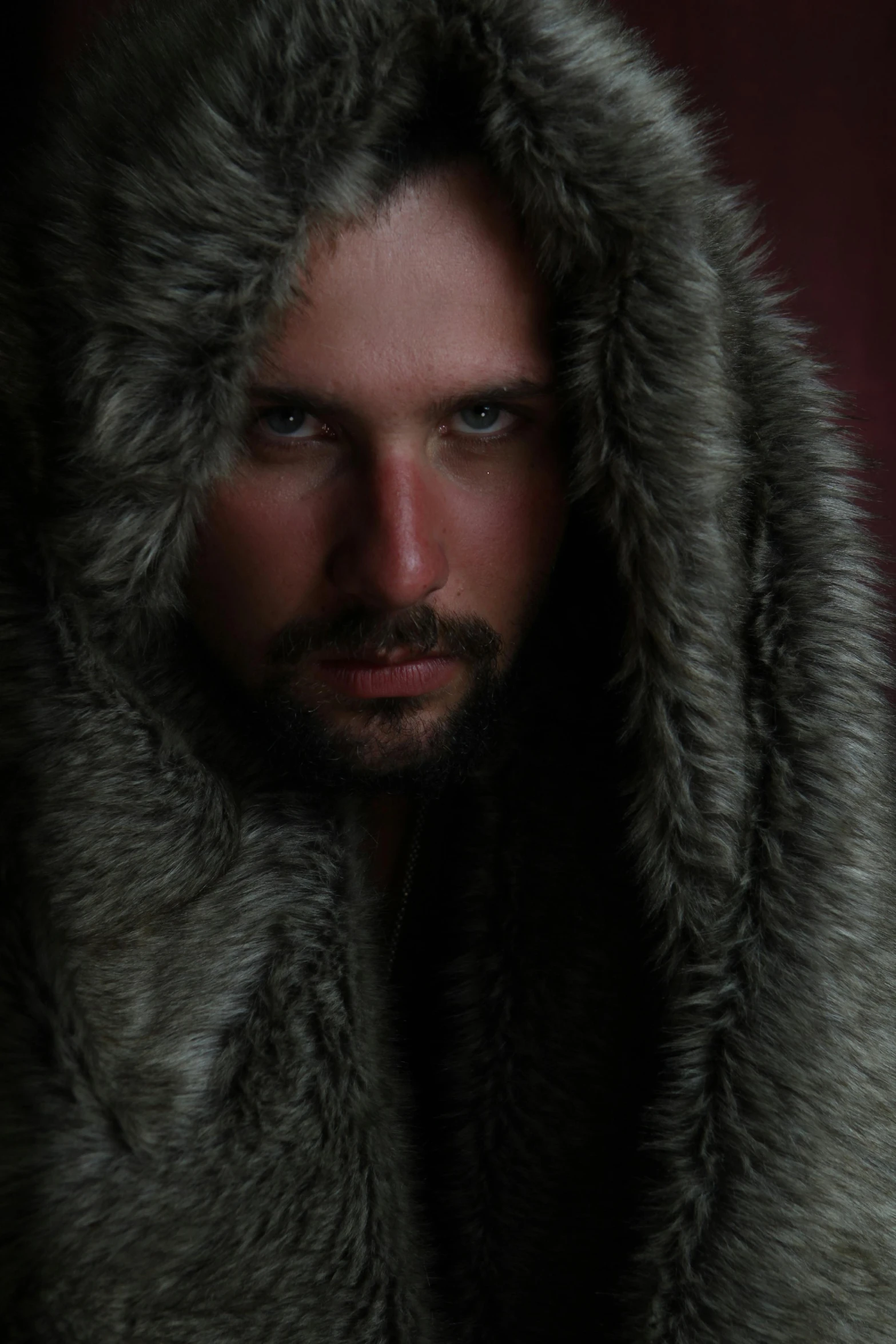 a man in a fur coat posing for a picture, a character portrait, inspired by Alasdair Grant Taylor, trending on reddit, krull, seductive stare, studio photo, fur hood