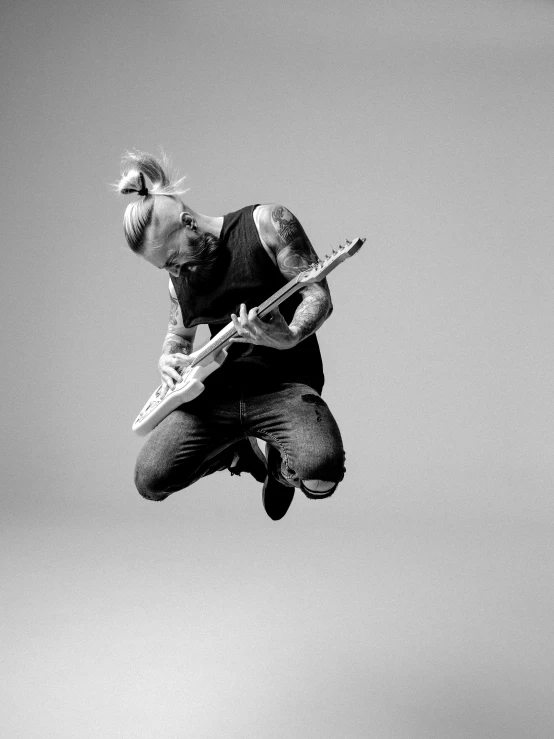 a man jumping in the air with a guitar, inspired by Seb McKinnon, ian david soar, beth cavener, vesa-matti loiri, extreme realism