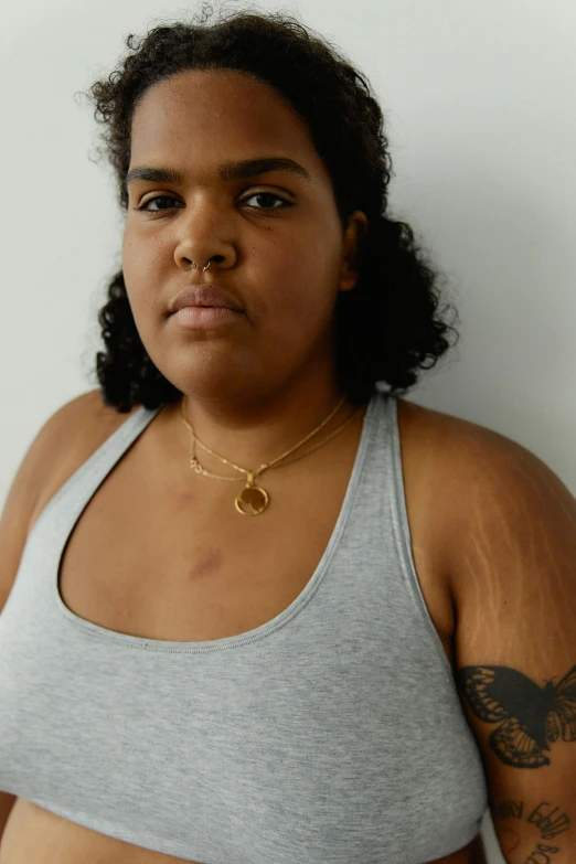 a woman with a tattoo on her arm, an album cover, by Jessie Alexandra Dick, featured on reddit, gold necklace, medium skin tone, obese, photographed for reuters