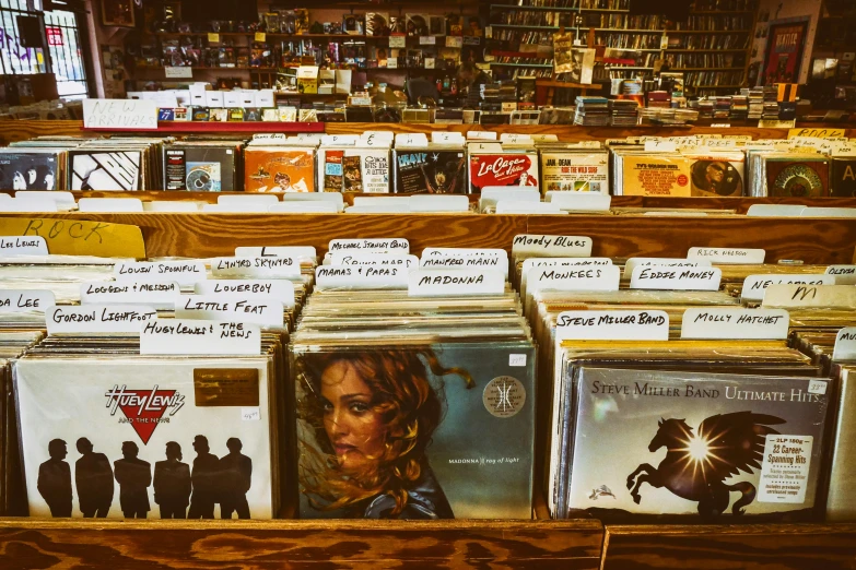 a number of records on a shelf in a store, an album cover, pexels, americana, hillside, thumbnail, low fi