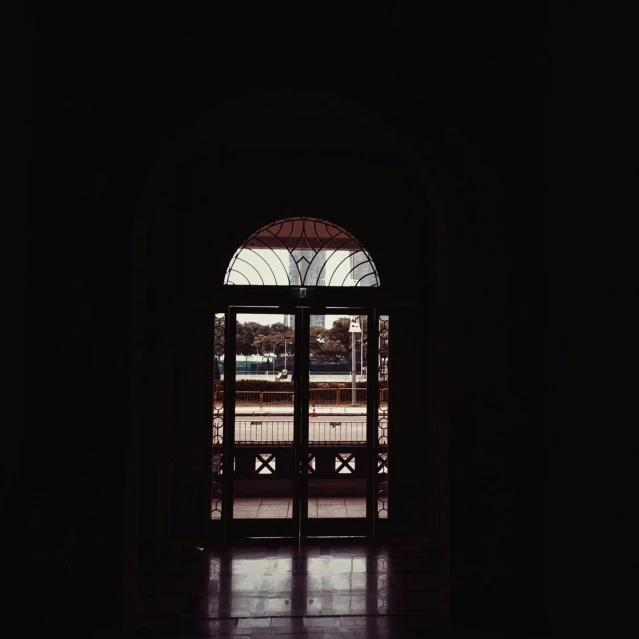 an open door in a dark room, by Ahmed Yacoubi, in balcony of palace, dark university aesthetic, with instagram filters, shot on sony a 7