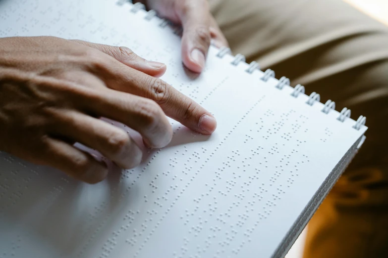 a close up of a person holding a book, trending on pexels, ascii art, marfan syndrome, blind, writing on a clipboard, schools