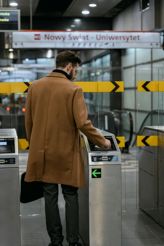 a man standing in front of a parking meter, pexels contest winner, back of emma stone in beige coat, black. airports, supersonic trains and passengers, thumbnail