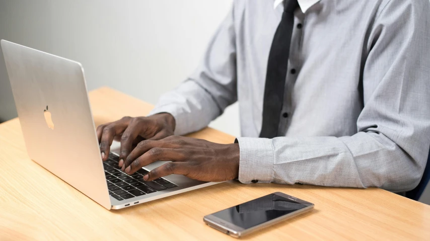 a man sitting at a desk using a laptop computer, trending on pexels, royal commission, any racial background, background image, government archive photograph