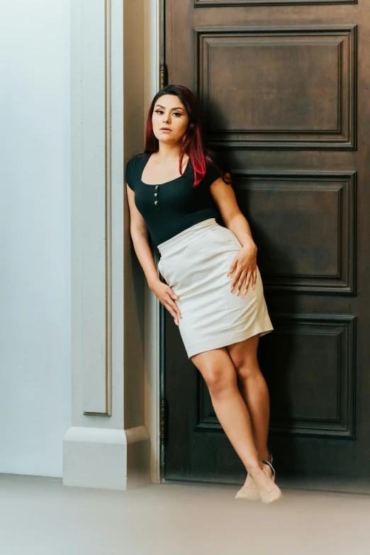 a woman leaning against a door with her hands on her hips, a portrait, by Julia Pishtar, mini skirt, katarina, portait image