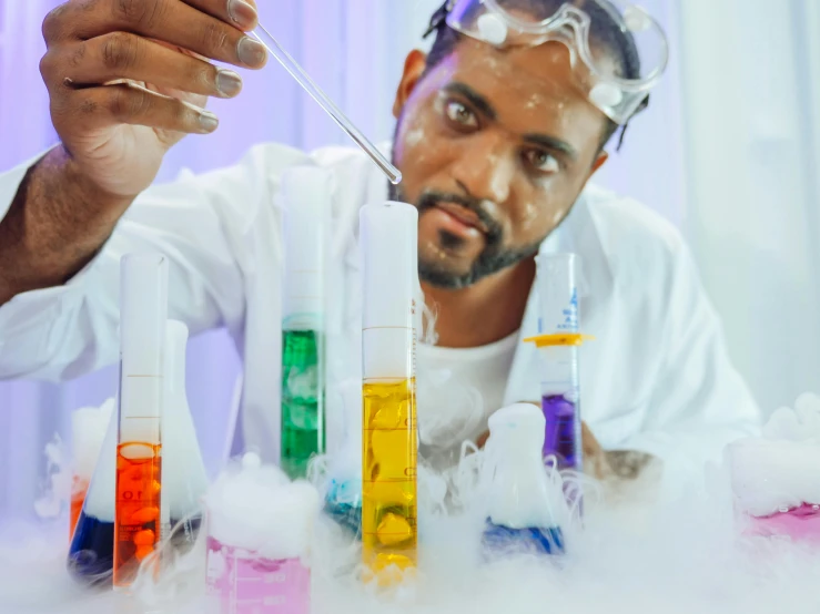 a man is doing a science experiment in a lab, an album cover, pexels contest winner, photoshoot for skincare brand, brightly coloured smoke, mkbhd, clean white lab background