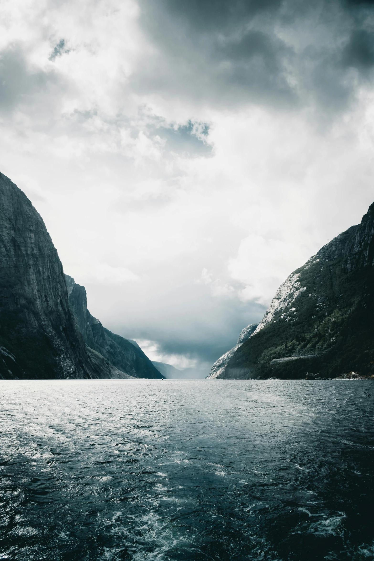 a body of water surrounded by mountains under a cloudy sky, fjords, steep cliffs, epic photo, scandinavian / norse influenced