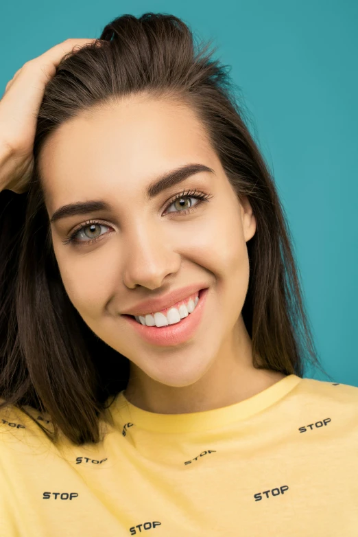 a woman in a yellow shirt smiles at the camera, trending on pexels, teal eyebrows, pokimane, photoshoot for skincare brand, avatar image