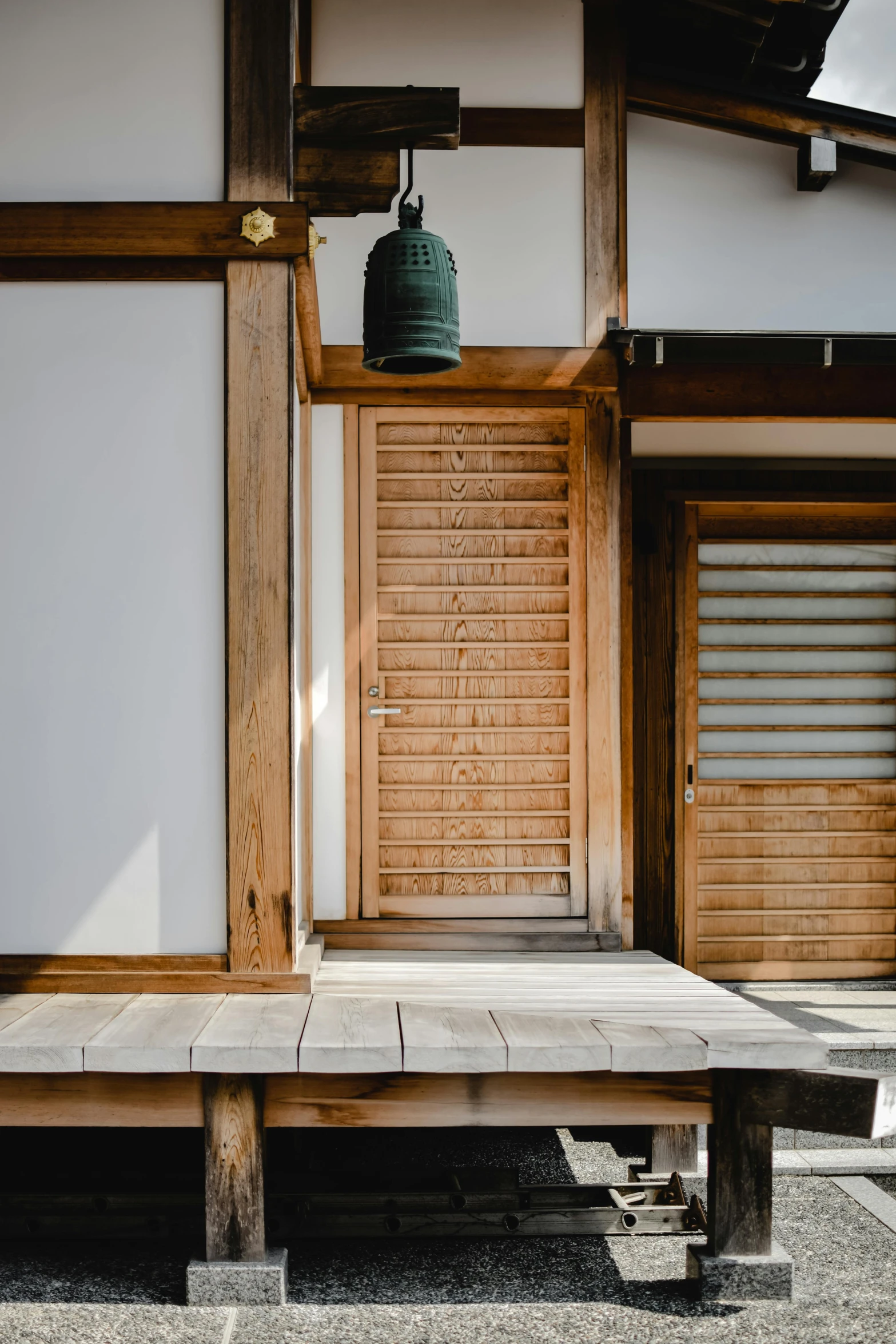 a bell sitting on top of a wooden platform, inspired by Ogata Kōrin, unsplash, shin hanga, balcony door, tall entry, front lit, 2070s