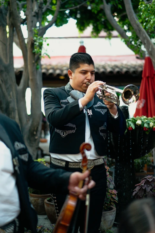 a man in a black jacket playing a trumpet, by Alejandro Obregón, happening, tlaquepaque, funeral, promo image, tacos