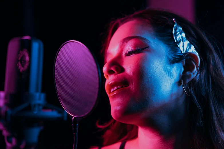a woman singing into a microphone in a recording studio, an album cover, pexels, coloured gel studio light, songlines, with head phones, profile image