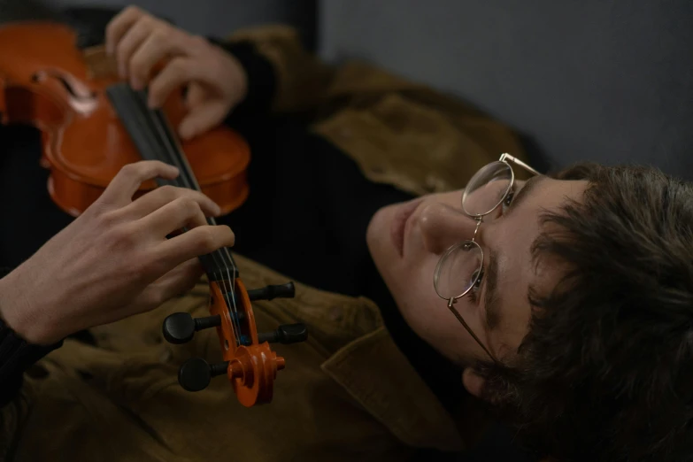 a close up of a person holding a violin, jewish young man with glasses, taken with sony alpha 9, avatar image, sleepy