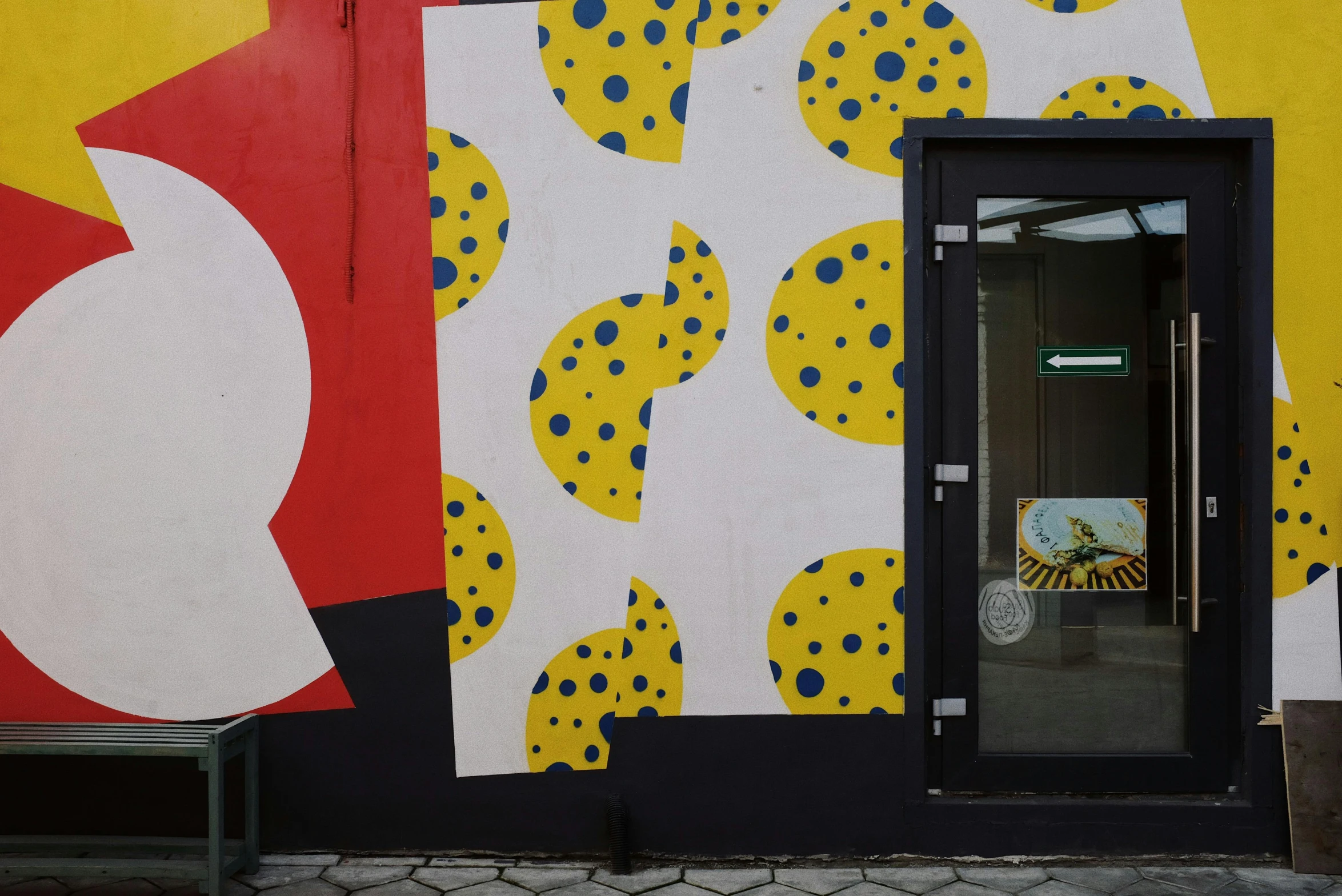 a large painting on the side of a building, a pop art painting, inspired by Patrick Caulfield, unsplash, berlin secession, stood outside a corner shop, dots abstract, yellow scheme, 2 0 0 0's photo