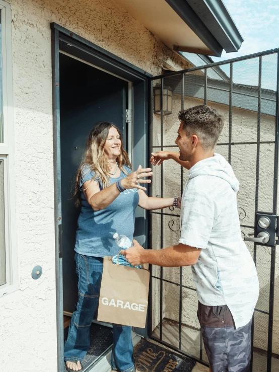 a man handing a package to a woman, a photo, by Josh Bayer, pexels contest winner, renaissance, garage, 🚀🌈🤩, opening door, smileing nright