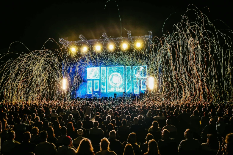 a large group of people standing in front of a stage, pyrotechnics, intricate illuminated lines, gopro photo, insanly detailed