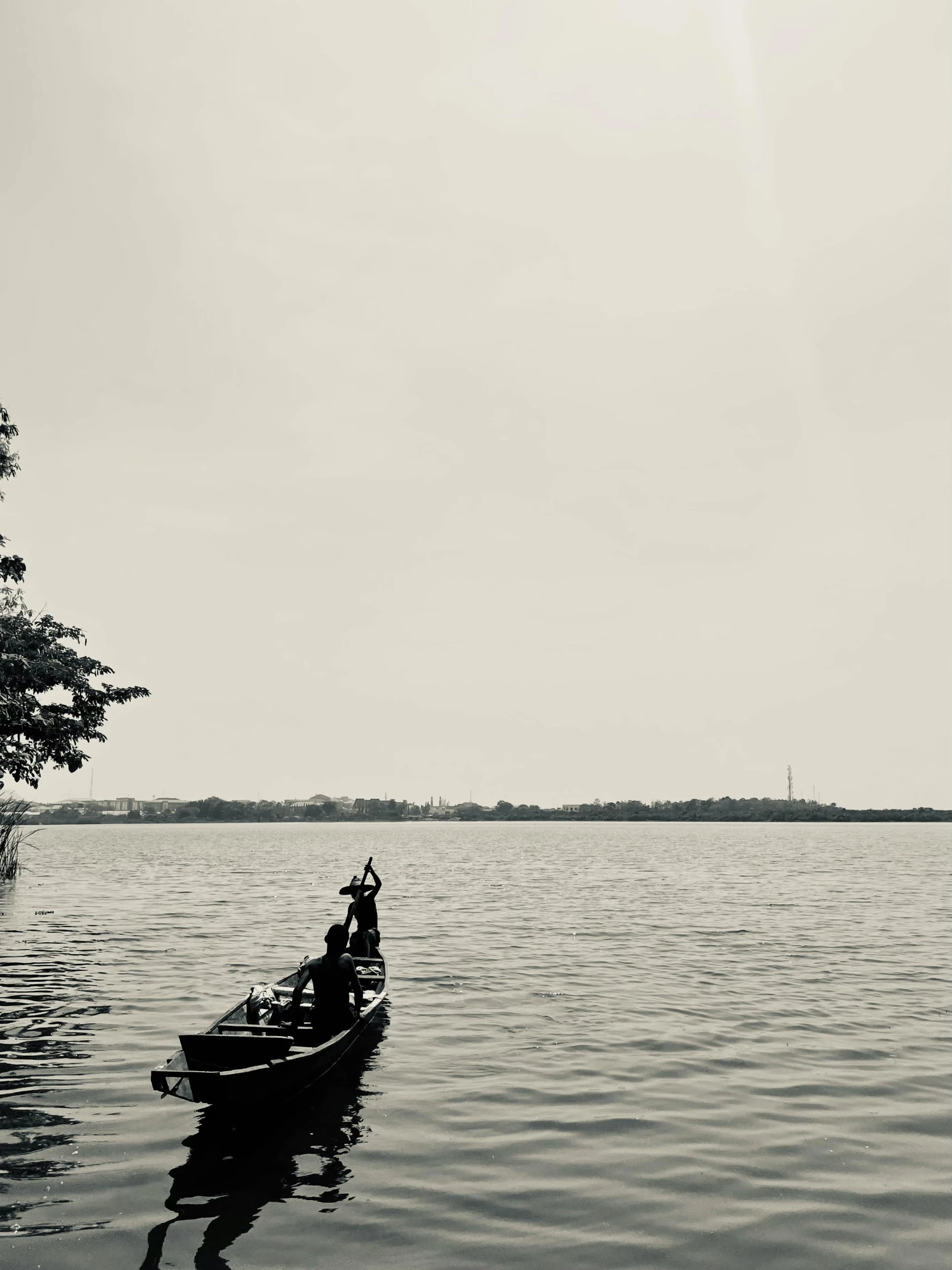 a black and white photo of a person in a boat, by Sunil Das, hurufiyya, lake view, ilustration, jakarta, distant view