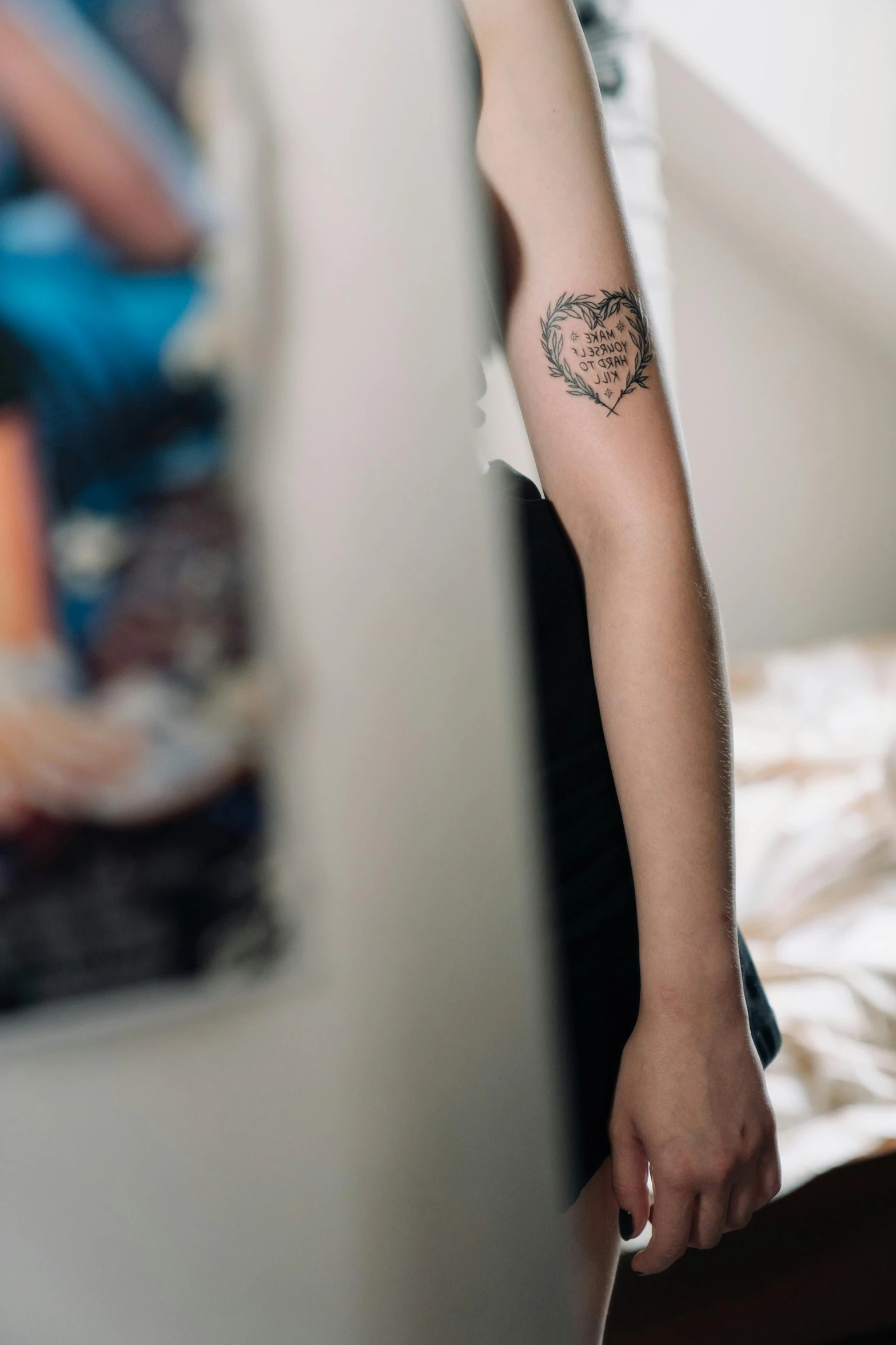 a woman with a tattoo on her arm, inspired by Elsa Bleda, trending on pexels, in a bedroom, zoomed out shot, teenage boy, anatomical heart