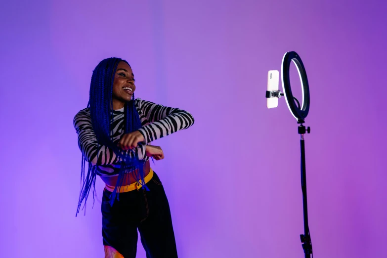 a woman that is standing in front of a camera, a picture, ring light, purple, in an action pose, photo of a black woman