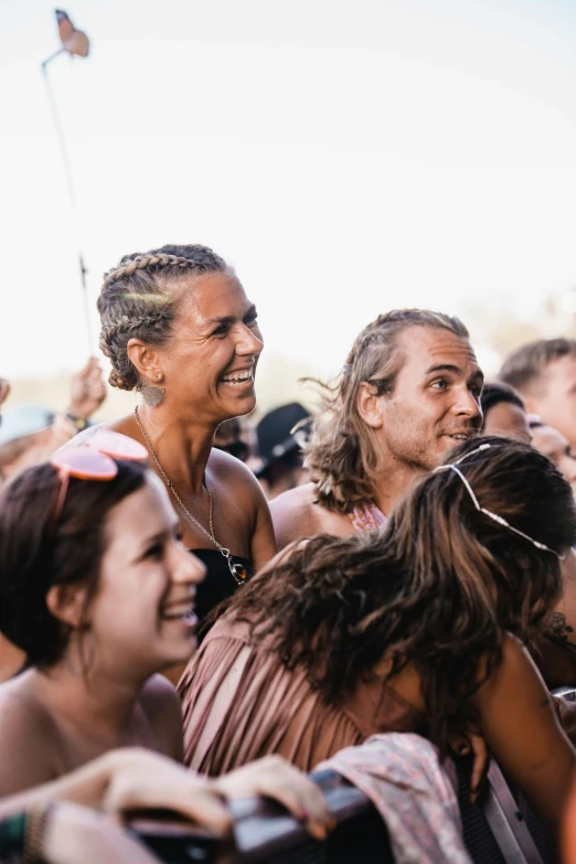 a man standing in front of a crowd of people, trending on unsplash, happening, beach party, very slightly smiling, indigenous, hair