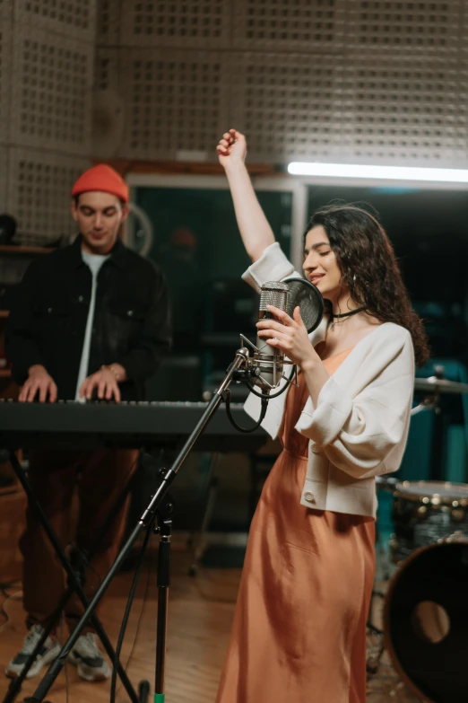 a woman standing in front of a microphone, an album cover, trending on pexels, playing piano, band, singing, pokimane