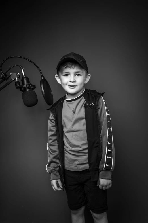 a young boy standing in front of a microphone, inspired by John Opie, studio medium format photograph, yaroslav tokar, postman pat, kid a