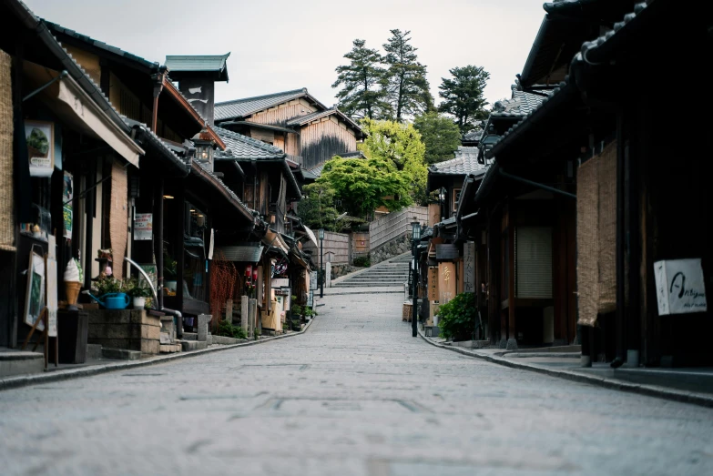 a narrow street lined with wooden buildings, inspired by Kaii Higashiyama, unsplash contest winner, mingei, tiled roofs, 2 0 0 0's photo, fan favorite, built on a steep hill