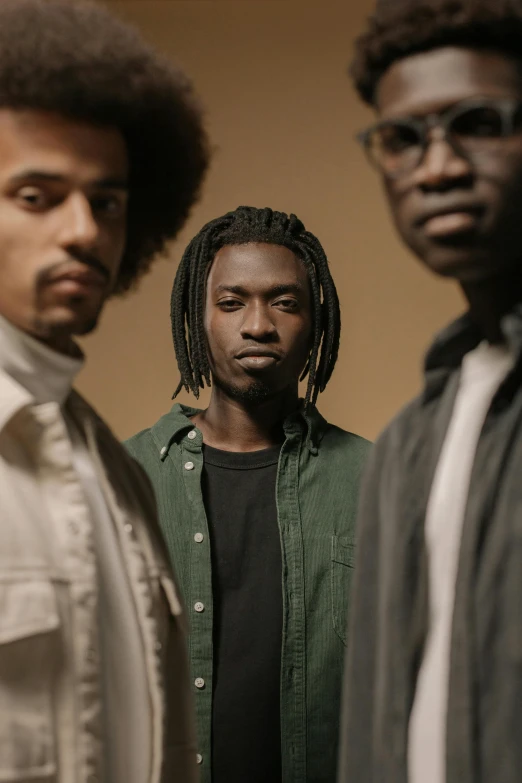 a group of men standing next to each other, an album cover, by Afewerk Tekle, pexels contest winner, neutral focused gaze, ( brown skin ), focused light, casual pose