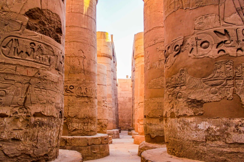 some very tall stone pillars with carvings on them, egyptian art, pexels contest winner, warm glow, huge support buttresses, promo image, delightful surroundings