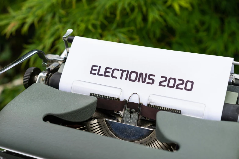 a close up of a typewriter with a paper on it, by Carey Morris, shutterstock, graffiti, election poster, imet2020, electrons, political meeting in the woods