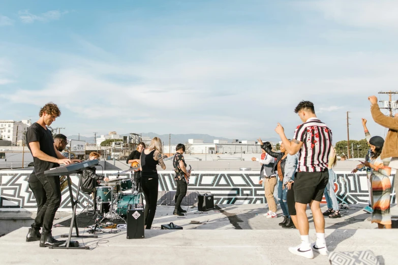 a group of people standing on top of a roof, an album cover, unsplash, happening, band playing, los angelos, wide long view, no watermarks
