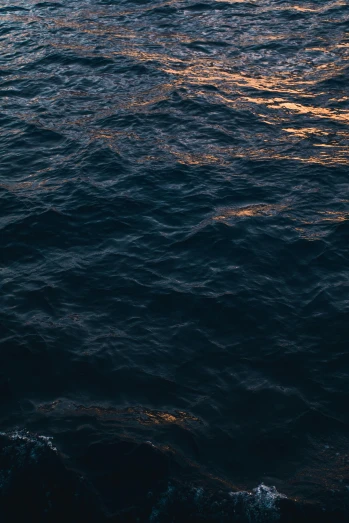 a view of a body of water at sunset, an album cover, inspired by Elsa Bleda, unsplash, minimalism, dark blue water, golden hour closeup photo, wavy, navy