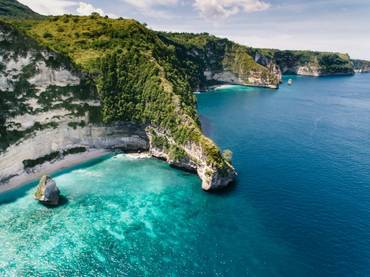 a large body of water next to a cliff, pexels contest winner, sumatraism, island in a blue sea, white beaches, beach is between the two valleys, movie