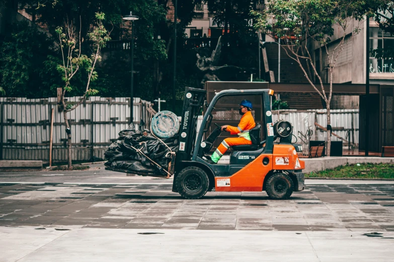 a man driving a forklift in a parking lot, pexels contest winner, arbeitsrat für kunst, plumbing jungle, tilt and orange, on the concrete ground, avatar image