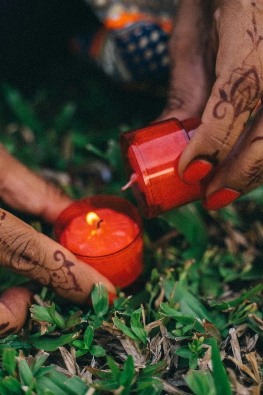 a close up of a person lighting a candle, red grass, spells, reggae, crafts and souvenirs