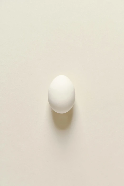 an egg sitting on top of a white surface, by Harvey Quaytman, wall ], 1/320, mozzarella, everyday plain object